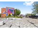 Exterior featuring a colorful mural, modern benches, landscaping, and ample street parking at 210 Walford Dr, Charlotte, NC 28208
