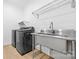 Clean laundry room with stainless steel sink and modern washer and dryer at 210 Walford Dr, Charlotte, NC 28208