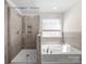 Modern bathroom featuring a separate shower and soaking tub surrounded with tile at 3042 Burnello Ct, Iron Station, NC 28080
