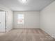 A bright, airy bedroom with neutral walls and carpet, illuminated by a window at 3042 Burnello Ct, Iron Station, NC 28080