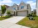 Two-story home featuring stone accents, a two-car garage, and a long concrete driveway at 3042 Burnello Ct, Iron Station, NC 28080