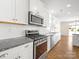 Bright kitchen with granite countertops, white cabinets, and stainless steel appliances at 3042 Burnello Ct, Iron Station, NC 28080