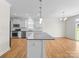 Contemporary kitchen with island, stainless steel appliances, and a view to the backyard at 3042 Burnello Ct, Iron Station, NC 28080