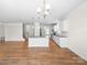 Open concept living space featuring kitchen island, hardwood floors, and staircase at 3042 Burnello Ct, Iron Station, NC 28080