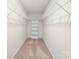 Walk-in closet featuring built-in shelving and carpeted flooring providing efficient storage at 3042 Burnello Ct, Iron Station, NC 28080