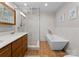 Bright bathroom featuring a glass shower, soaking tub, double vanity, modern fixtures, and wood look flooring at 315 Arlington Ave # 506 & 507, Charlotte, NC 28203