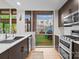 Modern kitchen with stainless steel appliances, dark cabinets, and a view of an outdoor patio, creating a cozy cooking space at 315 Arlington Ave # 506 & 507, Charlotte, NC 28203