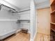 Walk-in closet with a bench, shelving and hanging-storage; features hardwood floors and gray walls at 315 Arlington Ave # 506 & 507, Charlotte, NC 28203