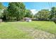 Expansive backyard featuring lush green grass, mature trees, and a storage shed, offering ample space for outdoor activities at 3203 Valleydale Rd, Monroe, NC 28110