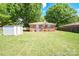 Well-maintained backyard with green lawn, a storage shed, and partial fence, providing a private outdoor space at 3203 Valleydale Rd, Monroe, NC 28110