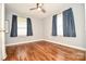 Cozy bedroom with hardwood floors, a modern ceiling fan, two windows, and light gray walls at 3203 Valleydale Rd, Monroe, NC 28110