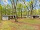 Back yard featuring multiple storage sheds with mature trees and grassy lawn at 322 S Main St, Shelby, NC 28152