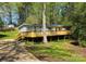 Ranch style home featuring a large front deck, light siding and blue shutters surrounded by mature trees at 3325 Stony Brook Cir, Newton, NC 28658