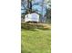 Outdoor shed set against a backdrop of lush green grass and mature trees at 3325 Stony Brook Cir, Newton, NC 28658