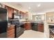 Functional kitchen with black appliances, tile backsplash, and cherry wood cabinets at 3420 Caldwell Ridge Pkwy, Charlotte, NC 28213