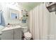 Cute bathroom with pastel green walls, white vanity, white shelves, and a shower with a white curtain at 3901 Parkers Fry None, Fort Mill, SC 29715