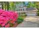 Captivating two-story home with a manicured lawn and vibrant pink azaleas bordering the driveway at 394 Runnymede Dr, Rock Hill, SC 29732