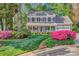 Charming two-story home featuring a welcoming front porch and a beautifully landscaped front yard with vibrant pink flowers at 394 Runnymede Dr, Rock Hill, SC 29732