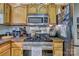 Close-up of a kitchen featuring a stainless steel range, granite counters, and wooden cabinets for a timeless appeal at 394 Runnymede Dr, Rock Hill, SC 29732