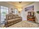 Cozy living room with a comfortable reclining sofa, soft carpet, and natural light from the windows at 394 Runnymede Dr, Rock Hill, SC 29732
