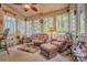 Cozy sunroom with wicker furniture, carpet flooring and plenty of natural light from the surrounding windows at 394 Runnymede Dr, Rock Hill, SC 29732