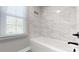 Bright bathroom featuring white tiled walls, and modern fixtures, perfect for relaxation at 4721 Myers Ln, Harrisburg, NC 28075