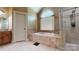 A stylish bathroom featuring a soaking tub, a glass shower, and neutral tile work at 4721 Myers Ln, Harrisburg, NC 28075