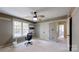 Bright, carpeted bedroom features a built-in desk, ceiling fan, and ample closet space at 4721 Myers Ln, Harrisburg, NC 28075
