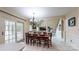 Bright dining area features a chandelier, tiled floors, and access to outdoor deck at 4721 Myers Ln, Harrisburg, NC 28075