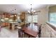 Open kitchen and dining area with wood cabinets, tile floors, an island, and backyard views at 4721 Myers Ln, Harrisburg, NC 28075