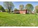 Expansive, grassy backyard featuring a brick home, deck, mature trees, and landscaped flower beds at 501 8Th Sw Ave, Conover, NC 28613