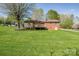Expansive green backyard featuring a brick home with a wooden deck, and mature trees at 501 8Th Sw Ave, Conover, NC 28613