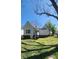 View of a charming home with a spacious backyard, featuring a well-maintained lawn and mature trees at 510 S Yadkin Ave, Spencer, NC 28159