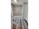Bathroom featuring modern tub and shower with marbled tiling, and wood-look floors at 510 S Yadkin Ave, Spencer, NC 28159