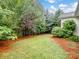 Spacious backyard with lush green grass, mature trees, and a black metal fence at 527 Livingston Dr, Lancaster, SC 29720