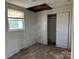 Bedroom with a window, closet, and visible water damage, showing property condition at 539 Jennings Rd, Statesville, NC 28625