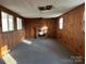 Spacious living room featuring wood paneled walls, carpeted floor, and brick fireplace at 539 Jennings Rd, Statesville, NC 28625
