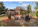 Brick patio with a fire pit and Adirondack chairs, perfect for outdoor entertaining and relaxation at 5629 Berry Ridge Dr, Harrisburg, NC 28075