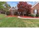 Beautiful brick home with a lush green lawn, manicured landscaping, and a charming walkway to the entrance at 5629 Berry Ridge Dr, Harrisburg, NC 28075