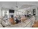Open-concept living room and kitchen featuring hardwood floors, a cozy fireplace, and modern lighting at 5629 Berry Ridge Dr, Harrisburg, NC 28075