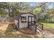 Charming storage shed with a ramp, window box with flowers, and a brick-lined garden bed at 5629 Berry Ridge Dr, Harrisburg, NC 28075