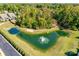 Aerial view of serene pond with fountain, surrounded by lush greenery and a residential area at 6024 Glenmore Garden Dr, Charlotte, NC 28270