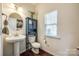 Charming powder room with stylish vanity, toilet, and a decorative mirror with great lighting at 6024 Glenmore Garden Dr, Charlotte, NC 28270