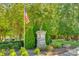 Community entrance sign for Glenmore, adorned with an American flag and manicured greenery at 6024 Glenmore Garden Dr, Charlotte, NC 28270
