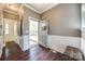 Inviting foyer featuring hardwood floors, elegant wainscoting, and a charming entry door with a decorative wreath at 6024 Glenmore Garden Dr, Charlotte, NC 28270