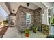 Inviting stone-clad front porch with decorative flower pots and a clear view of the home's address number at 6024 Glenmore Garden Dr, Charlotte, NC 28270