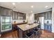 Gourmet kitchen boasts a large center island with granite countertops, stainless steel appliances, and stylish dark cabinets at 6024 Glenmore Garden Dr, Charlotte, NC 28270