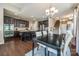 Gourmet kitchen features a spacious island, stainless steel appliances, dark cabinets, and hardwood flooring with stairs nearby at 6024 Glenmore Garden Dr, Charlotte, NC 28270