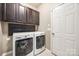 Functional laundry room equipped with a washer, dryer, upper cabinets, and a convenient folding shelf at 6024 Glenmore Garden Dr, Charlotte, NC 28270