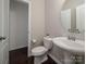 Powder room with a toilet, vessel sink, round mirror, and neutral paint at 6061 Piscataway Ct, Rock Hill, SC 29732